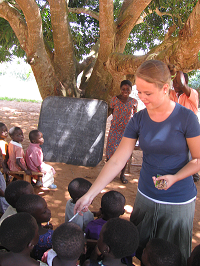 Laura Purias handing out pencils to school children.