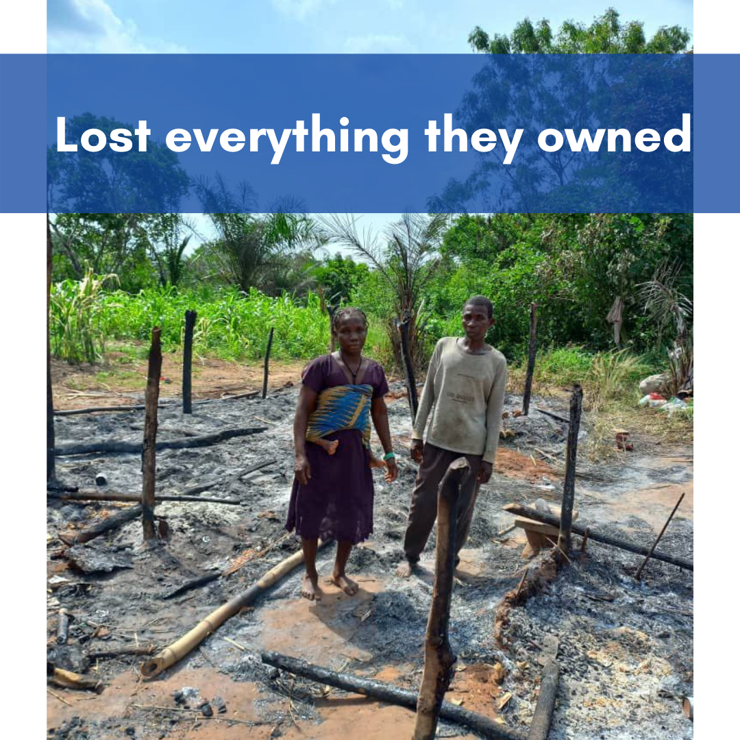 The distraught couple stands in the ashes where their mud hut used to be