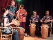 Five members of drumming group performing on stage