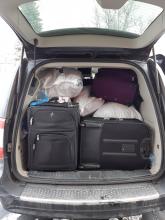 view of the back of Carol's van full to the roof with suitcases and shipping bags
