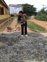 woman shovelling gravel at school entrance